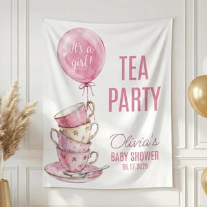 May include: A white banner with pink text reading "TEA PARTY" and "Olivia's BABY SHOWER 06.17.2026". A pink balloon says "It's a girl!" and is attached to a stack of teacups. Gold and white balloons are in the background.