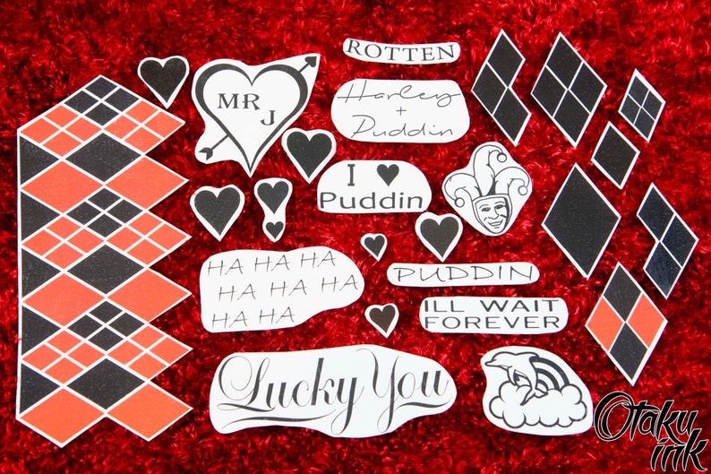 May include: A set of 15 temporary tattoos featuring various designs inspired by the character Harley Quinn. The tattoos include hearts, diamonds, text, and a jester's face. The text includes phrases like "Harley + Puddin", "I love Puddin", "Puddin", "Ill wait forever", "Lucky You", and "HA HA HA".