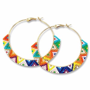 May include: A pair of gold hoop earrings with a colorful beaded design. The beads are arranged in a geometric pattern with shades of red, orange, yellow, green, blue, and white. The earrings have a classic hoop shape with a secure clasp.
