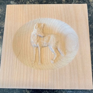 May include: A wooden plaque with a carved image of a coyote in an oval frame.
