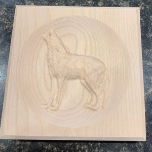 May include: A wooden plaque with a carved image of a wolf howling at the moon. The wolf is in a circular frame with a wood grain pattern.