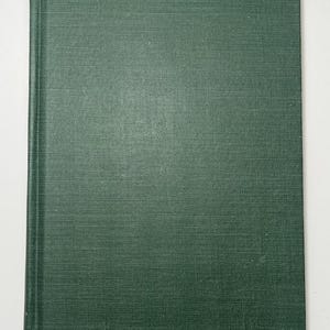 May include: A rectangular hardcover book featuring a solid dark forest green fabric cover with a visible woven texture. The book is oriented vertically, displaying a clean, plain front cover with a distinct spine edge running along the left side.