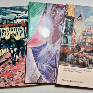 May include: Four auction catalogs from Christie's New York, each featuring distinct art on the cover. The rightmost catalog is titled Impressionist and Modern Paintings, Drawings and Sculpture, dated Thursday, February 18, 1988, with a street scene.