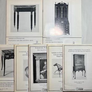 May include: A collection of seven Christie's auction catalogs featuring black and white cover illustrations of antique furniture, paintings, and decorative objects. Each catalog includes printed text detailing the auction contents and dates.
