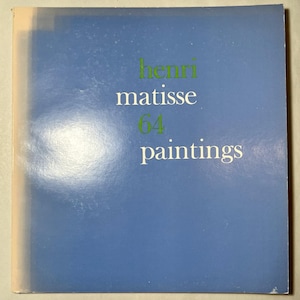 May include: A book cover with a blue background and the words "henri matisse 64 paintings" in white and green. The book appears to be a collection of Matisse's paintings.