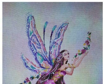 Könnte beinhalten: Kreuzstichmuster einer Fee mit schillernden Flügeln, die ein rosa-gelbes Kleid trägt. Die Fee hält eine Blumengirlande. Der Text "Fairy Iridescence" befindet sich am unteren Rand des Bildes.