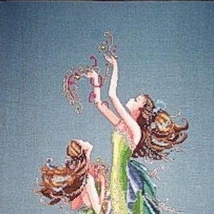 May include: Two mermaids with long flowing green tails and brown hair. The mermaid on top is holding a string of pearls and is looking up. The mermaid on the bottom is looking to the side. The background is a light blue.