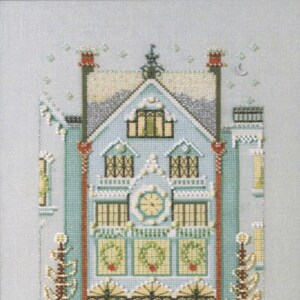 May include: A cross-stitch pattern of a blue house with white trim and a clock on the front. The house is decorated with wreaths and lights. There are two trees on either side of the house.