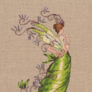 Puede incluir: Un hada verde y amarilla con alas y un largo vestido fluido. El hada está bordada con cuentas moradas y tiene un delicado diseño floral.