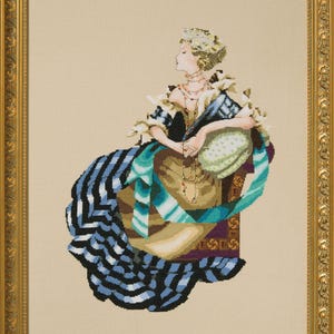 Może przedstawiać: Haft krzyżykowy przedstawiający kobietę w historycznej sukni, siedzącą na krześle. Suknia ma niebiesko-czarną tkaninę w paski, z akcentami turkusu i złota. Dzieło jest oprawione w złotą, ozdobną ramę.