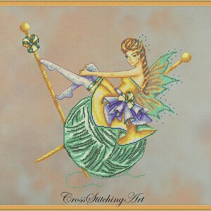 May include: A cross stitch pattern featuring a fairy sitting on a large ball of yarn with two knitting needles. The fairy has brown hair, a yellow dress, and green wings. The yarn is green and the needles are yellow.