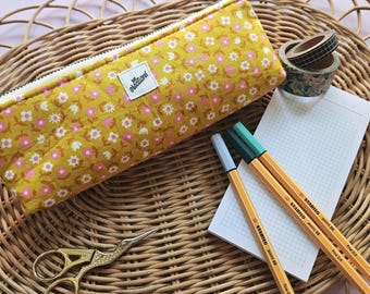 May include: A yellow floral pencil case with a white zipper, a small label that says "creations", and a collection of stationery items. Includes a pair of gold scissors, notebooks, pens, and decorative tape. The pencil case is approximately 9 inches long.