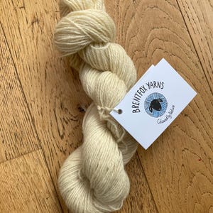May include: A skein of cream-coloured yarn with a white label that reads "Brentfox Yarns" and "Coloured by Nature".