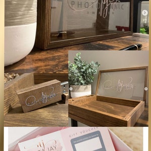 K&ouml;nnte beinhalten: Eine wei&szlig;e Geschenkbox mit rosa Seidenpapier und einem wei&szlig;en gestrickten Hasen. Die Box enth&auml;lt einen Geschenkgutschein und eine Visitenkarte f&uuml;r Nikita Jay Photography. Die Visitenkarte hat einen Aquarellhintergrund mit dem Text "Nikita Jay Photography" in einer kursivschrift.