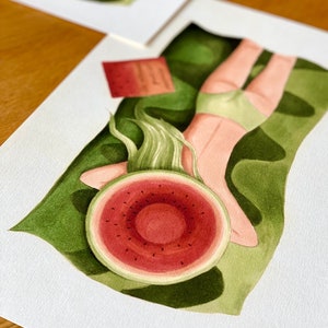 May include: A watercolor painting of a person lying on a green background with a watermelon slice over their head. The person is wearing a green swimsuit and has long green hair.