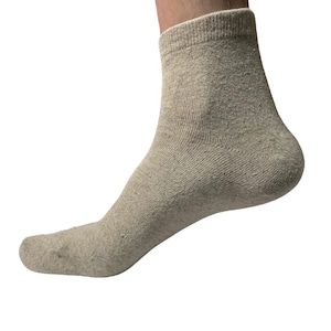 May include: A pair of beige ankle socks made of cotton.