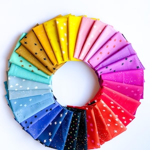 May include: A circular arrangement of colorful fabric squares, each folded to display a star pattern. The fabrics range in color from gold to red, with white stars. The arrangement is on a white background.