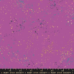 May include: A vibrant purple fabric with a speckled design. The fabric features a pattern of small, irregular dots in shades of gold, teal, and navy blue, scattered across the surface. The text "RUBY STAR SOCIETY" is printed along the bottom edge.