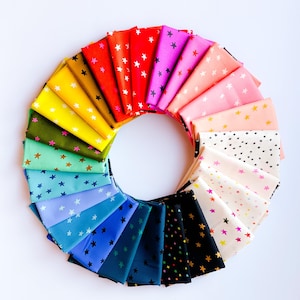 May include: A circular arrangement of folded fabric swatches in a spectrum of colors including red, orange, yellow, green, blue, purple, pink, white, and black. Each piece of fabric features a repeating pattern of small, contrasting stars.