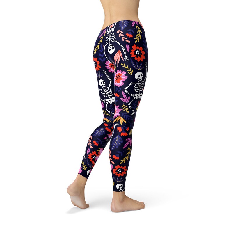 May include: Black leggings with a floral and skeleton pattern. The flowers are pink, red, and yellow. The skeletons are white.