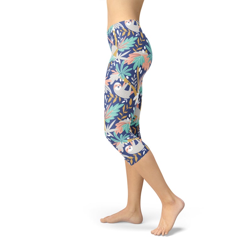 May include: Blue capri leggings with a pattern of sloths hanging from trees and tropical leaves.