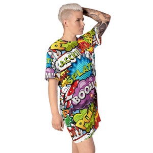 May include: A white t-shirt dress with a colorful comic book print featuring words like "BOOM!" and "SPLAT!"