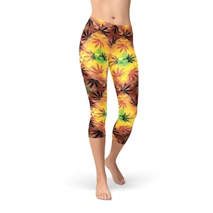 May include: Yellow, orange, and green geometric pattern leggings with a cannabis leaf design. The leggings are cropped and have a high waist.