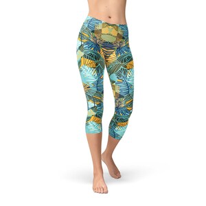 May include: Cropped leggings with a tropical leaf pattern in shades of blue, green, yellow, and brown.