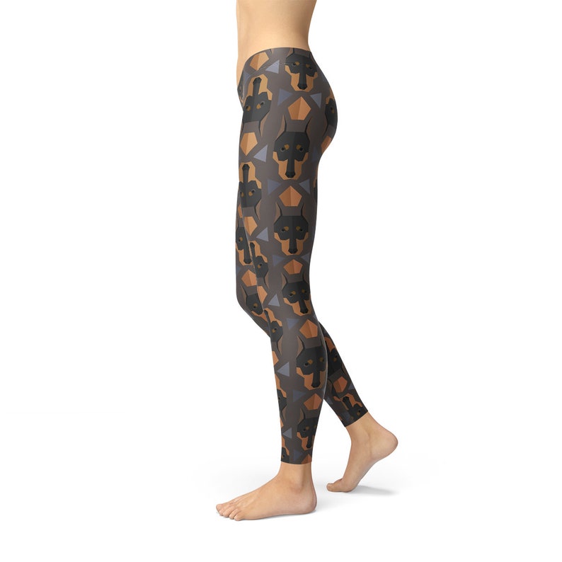 May include: Black leggings with a geometric pattern of brown and black Doberman Pinscher dog faces.