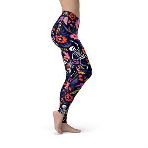 May include: Black leggings with a floral and skeleton print. The flowers are red, pink, and yellow. The skeletons are white.