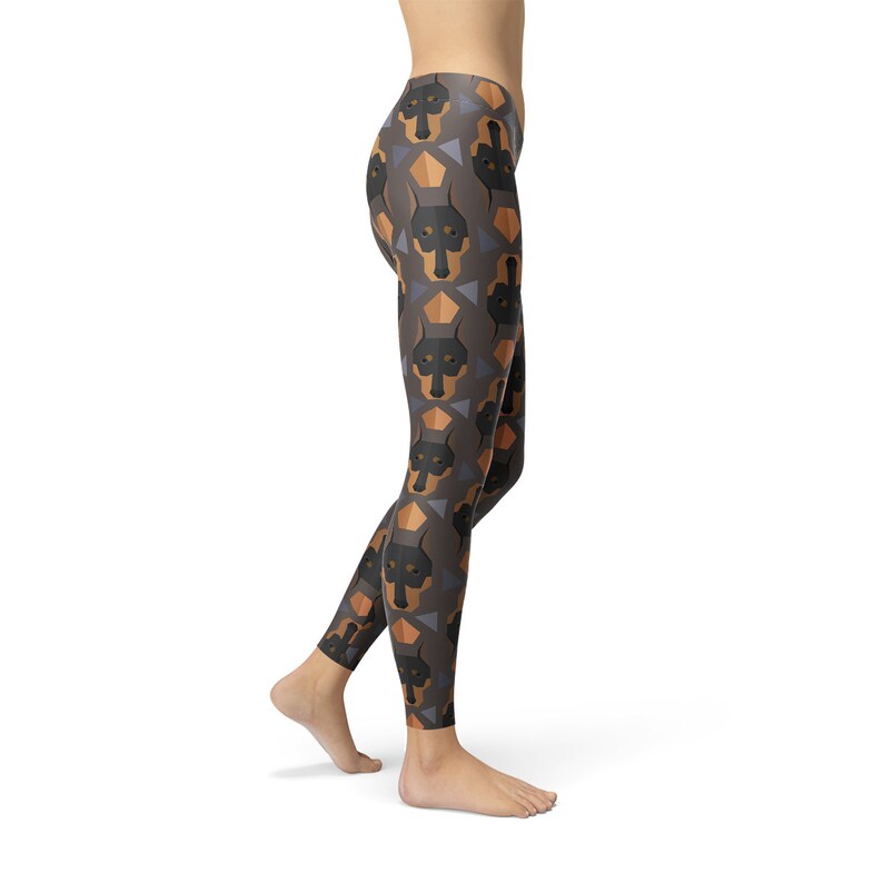May include: Black and brown leggings with a geometric pattern of Doberman Pinscher dog faces.