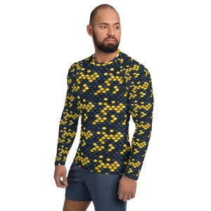 May include: A long-sleeved shirt with a black background and a yellow and blue scale pattern.