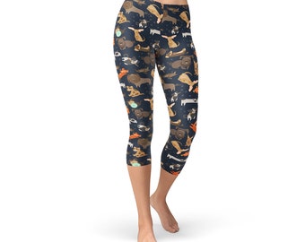 May include: Cropped leggings with a dark blue background and a repeating pattern of colorful cartoon dogs.