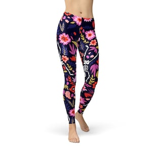 May include: Black leggings with a floral and skeleton print. The flowers are pink, red, orange, and yellow. The skeletons are white.