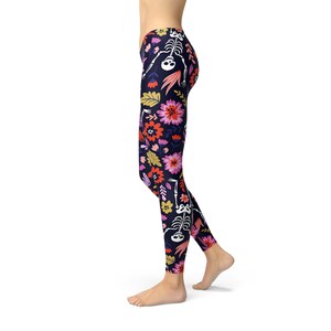 May include: Black leggings with a floral and skeleton print. The flowers are pink, red, yellow, and orange. The skeletons are white.