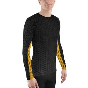 May include: Black long-sleeve shirt with a honeycomb pattern. The sleeves have a yellow dotted design. The shirt is made of a stretchy material and is suitable for athletic activities.