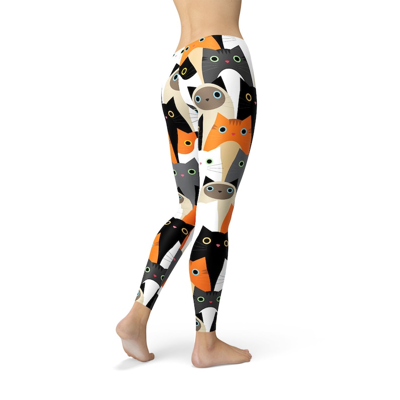 May include: Black, white, orange, and gray leggings with a repeating pattern of cats. The cats have different colored eyes and are looking in different directions.