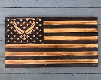May include: A wooden American flag with a burnt wood finish. The flag has a United States Air Force emblem in the canton.