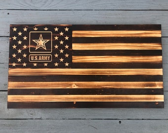 May include: A wooden American flag with a burnt finish. The flag has a white star in a blue square with the text "U.S. ARMY" below the star.