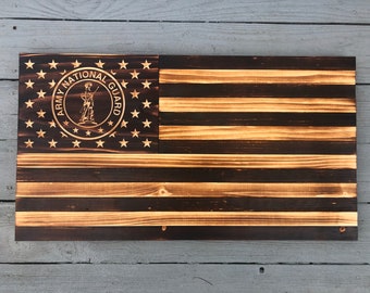 May include: A wooden American flag with a burnt finish. The flag has a circle in the top left corner with the words "Army National Guard" and a soldier holding a rifle.