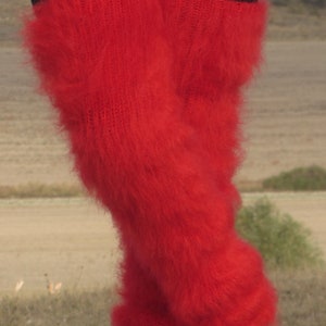 May include: Red fluffy leg warmers made of mohair yarn. The leg warmers are folded over at the top and bottom, creating a fluffy look.
