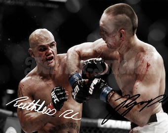 May include: Two mixed martial arts fighters in a boxing ring, both with blood on their faces and bodies. One fighter is wearing blue and black boxing gloves, the other is wearing black and white gloves. The fighter on the left has signed his name "Ruthless" and the fighter on the right has signed his name "J.J.  Diaz".