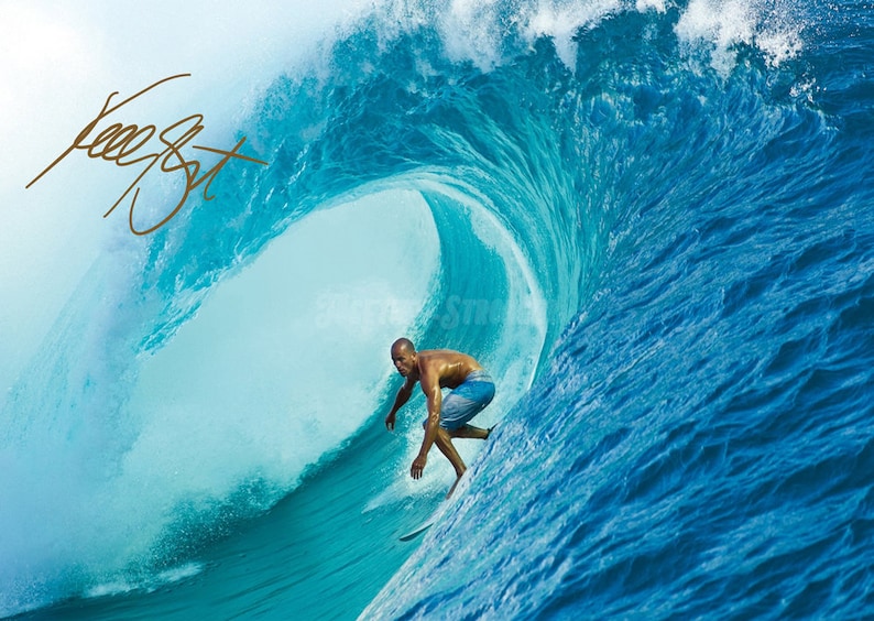 May include: A surfer rides a large, blue wave. The wave is breaking and creating a barrel. The surfer is wearing blue swim trunks and is paddling with his right hand.