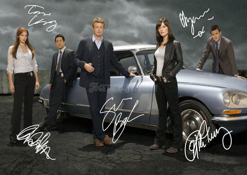 May include: A group of five people stand in front of a silver car. The people are all wearing casual clothing. The car has a signature on the side that says "The Mentalist".