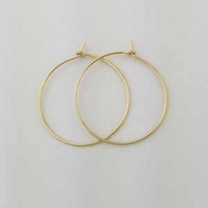 May include: A pair of gold hoop earrings. The earrings are simple and elegant, and they would be a great addition to any jewelry collection.