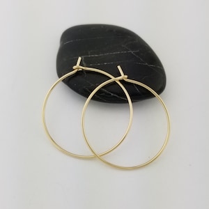 May include: A pair of gold hoop earrings. The earrings are simple and elegant, and they would be a great addition to any jewelry collection.