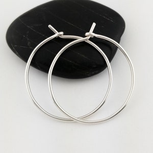 May include: A pair of silver hoop earrings. The earrings are simple and elegant, and they would make a great gift for any occasion.