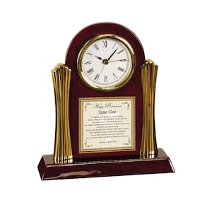 May include: A mahogany wood clock with gold accents and a plaque that reads "Happy Retirement Jane Doe".