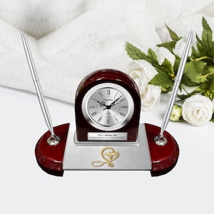 May include: A mahogany desk clock and pen set with a silver face clock and gold accents. The clock face reads "Alligator Quartz". The plaque reads "Tim J. Walker, RN 10 years of service at St. Vincent Hospital".