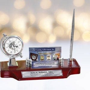 May include: A silver desk organizer with a globe clock, pen holder, and business card holder. The organizer is on a mahogany base with a personalized plaque that reads "Jackie K. McDaniels, MBA".